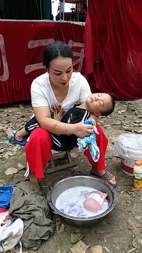 抱着小孩洗衣服，辛苦啦
